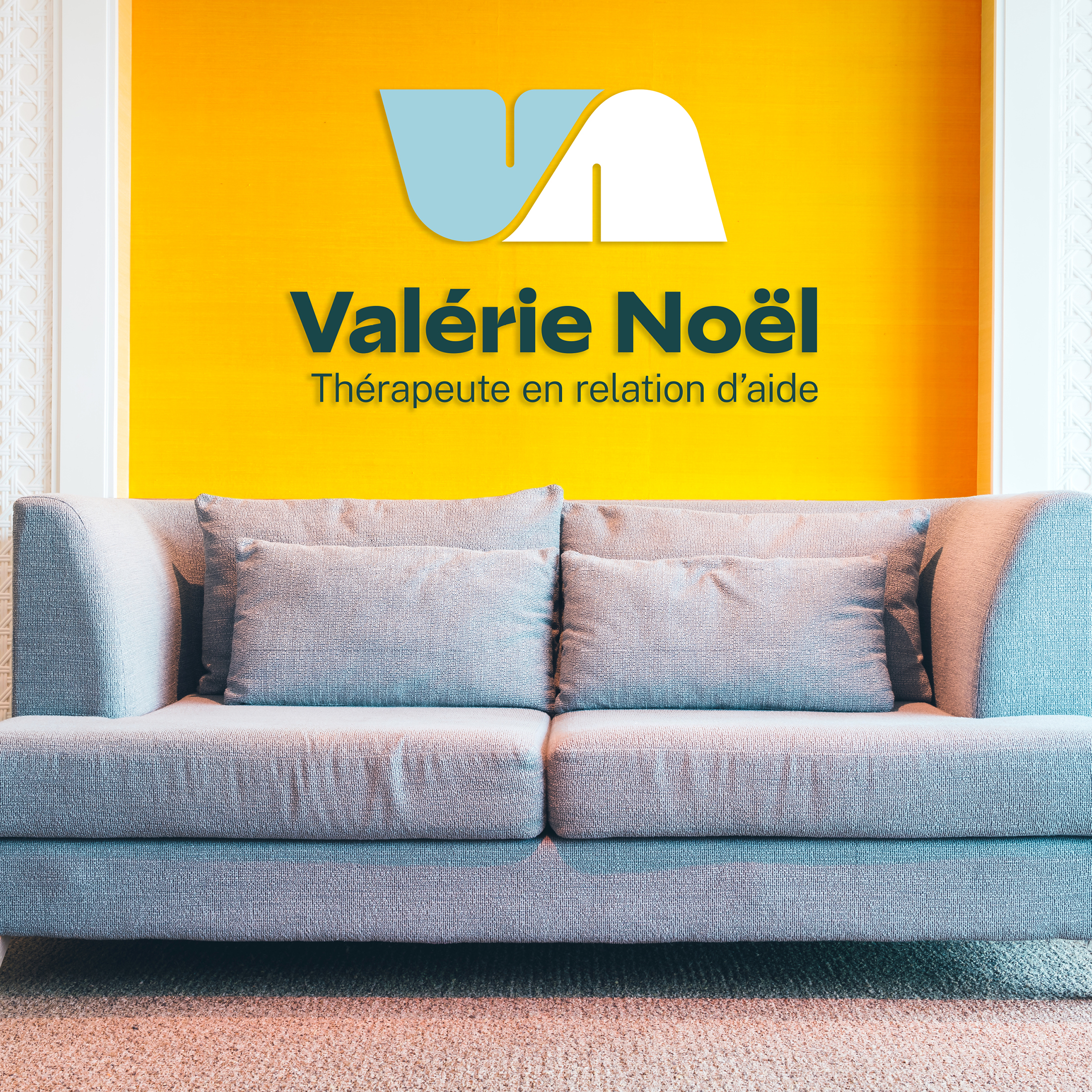 Un canapé gris pâle posé contre un mur jaune vif avec un logo et un texte indiquant